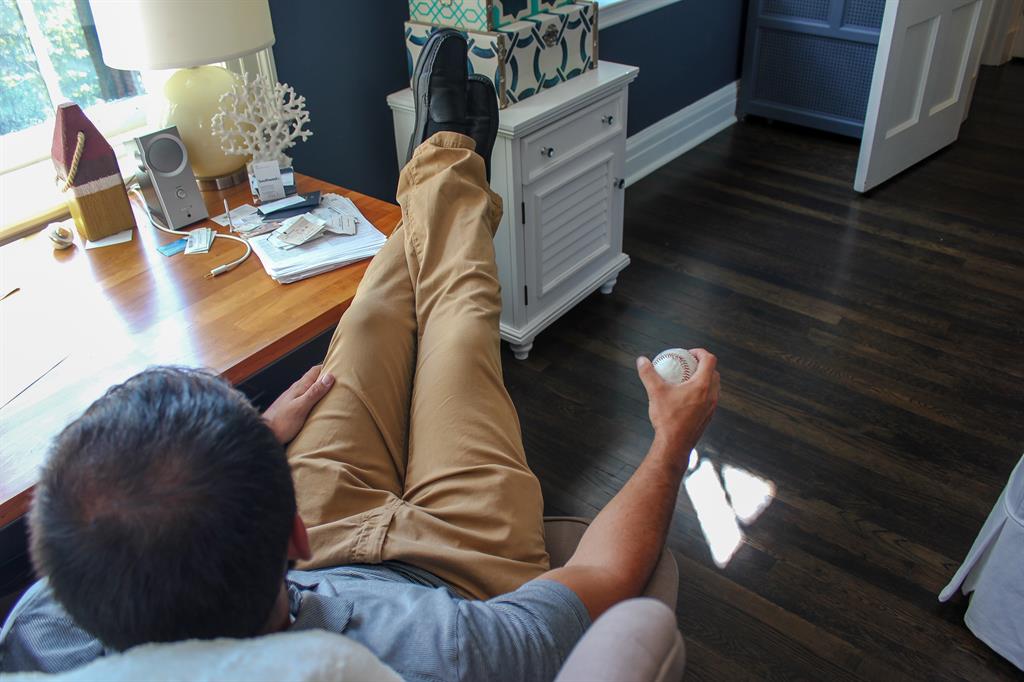 man sitting in a chair with a wood floor under him