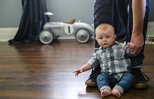 baby sitting on a wood floor