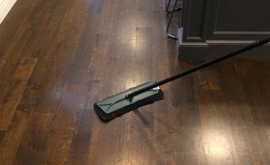 a floor duster being used to care for wood floor
